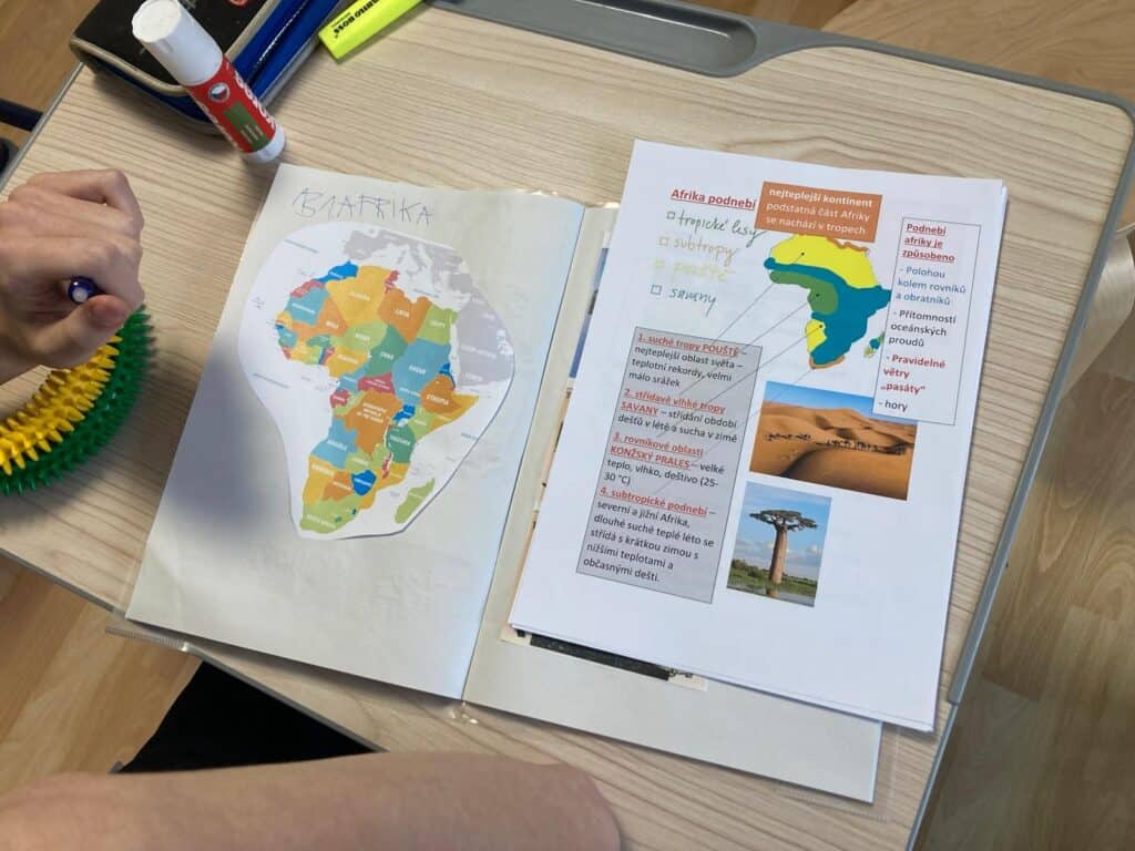 Barevný obrázek Afriky s názvem "KARIBIKA" na učebnici.